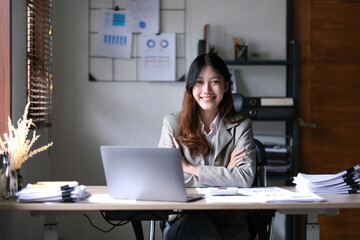 Fototapeta na wymiar business Asian woman working online at home office and looking at the camera.