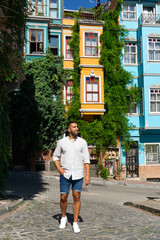 Fototapeta na wymiar Young man on an Istanbul street with colorful buildings