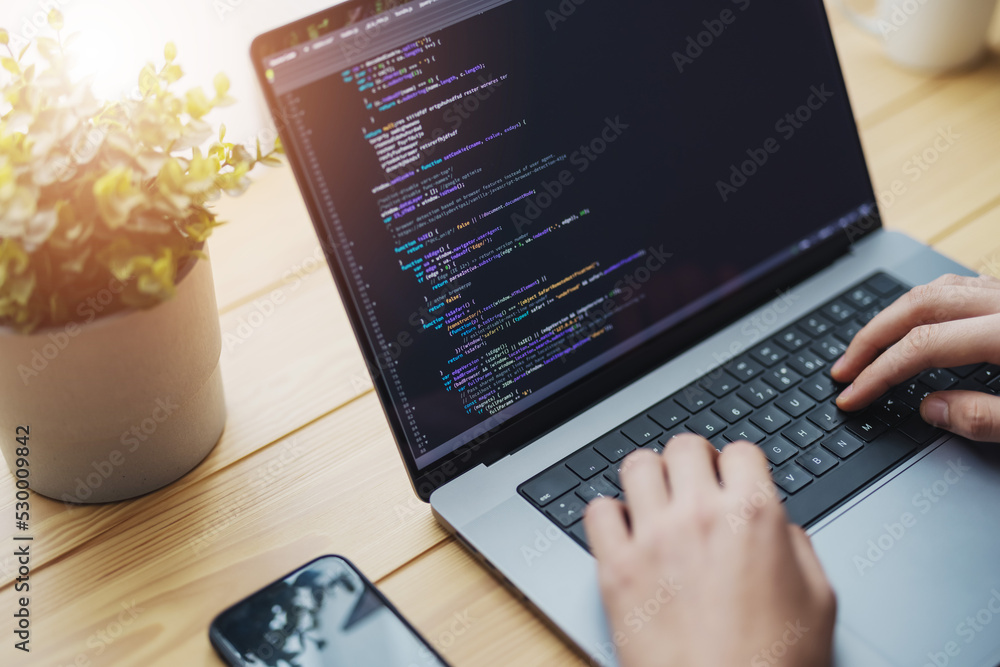 Poster man coding on laptop on a desk, remote working from home