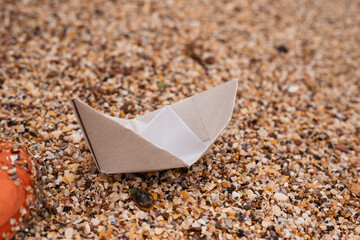 paper boat on sand near sea