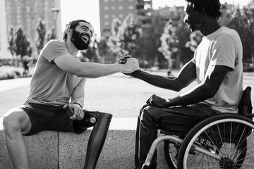 Multiethnic friends with disability greeting each other at park city - Focus on left man face -...