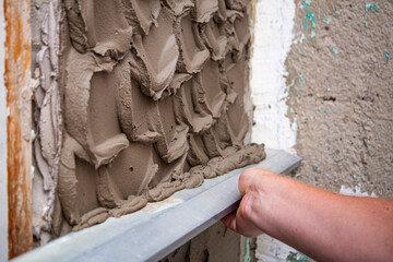 close up hand worker plastering cement on wall for building house