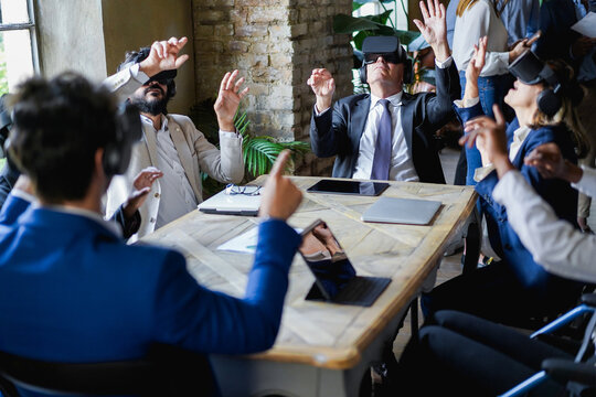 Business people wearing virtual reality goggles inside office - Focus on senior man face