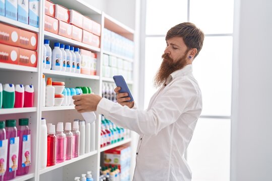 Young redhead man customer make photo by smartphone to medicine bottle at pharmacy