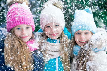 Beautiful portrait of three girl friends in snowy forest.