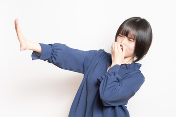 悪臭に困って鼻をつまんでいる若い女性