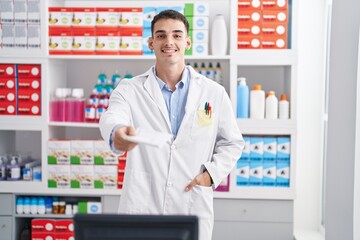 Young hispanic man pharmacist smiling confident holding prescription at pharmacy