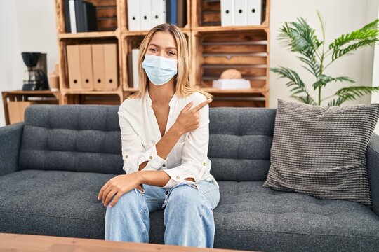 Young Blonde Woman Treating Covid Fear At Therapy Smiling Cheerful Pointing With Hand And Finger Up To The Side