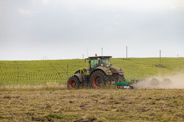 Fototapeta premium Ryazan, Russia - August 30, 2022: tractor plows the ground
