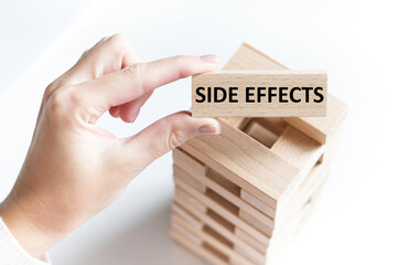 Side effects text on a wooden bar on the background of the table. Medical concept