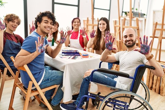 Group of people showing painted palm hands sitting on the table art studio.