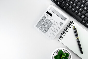 top view of modern white office desk with computer keyboard, blank notebook page and other equipment on white background. Workspace concept, workspace management style, business design space with copy