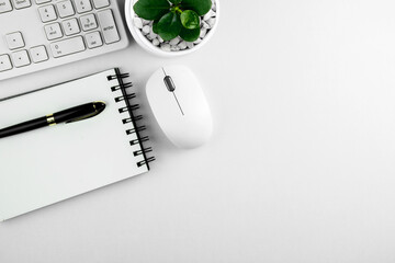 top view of modern white office desk with computer keyboard, blank notebook page and other equipment on white background. Workspace concept, workspace management style, business design space with copy