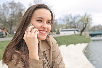 young woman in a park speaks on the phone