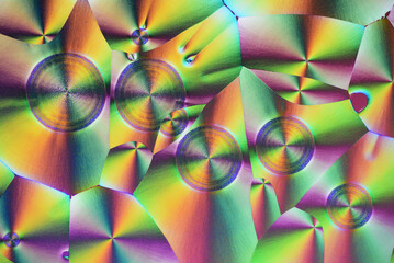 Colorful micro crystals in polarized light. Photo through a microscope.