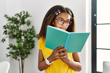 African american girl reading book at home