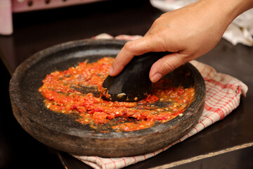 Grinding chili with stone or manual process of making chili sauce