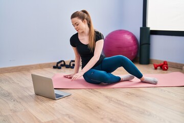 Young blonde woman having online training class at sport center