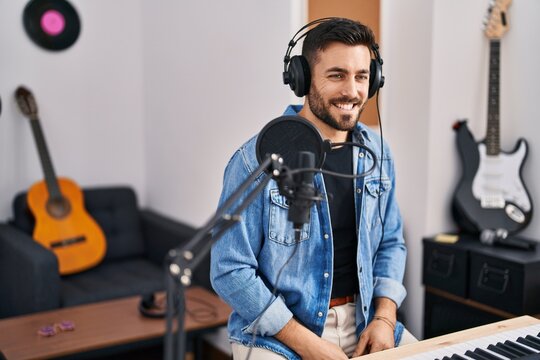 Young hispanic man artist smiling confident at music studio