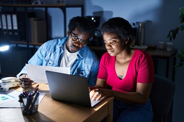 African american man and woman business workers using laptop working at office