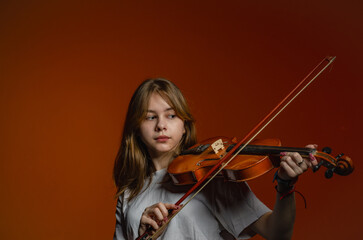 a girl with a violin on a dark background, wearing a white T-shirt