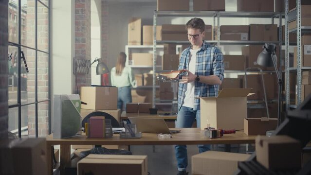 Inventory Manager Packaging a Stylish Bicycle Seat Sold to a Client Online. Preparing a Small Cardboard Parcel for Postage. Young Small Business Owner Working in Warehouse with Employees.