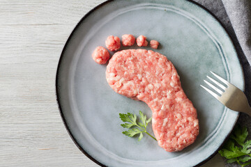 Carbon footprint concept, meat consumption and CO2 emissions, meat on foot-shaped plate,...