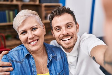 Fototapeta premium Mother and son make selfie by the camera sitting on sofa at home