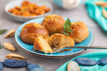 Traditional turkish dessert sekerpare with almonds and honey on gray concrete, side view, selective focus.