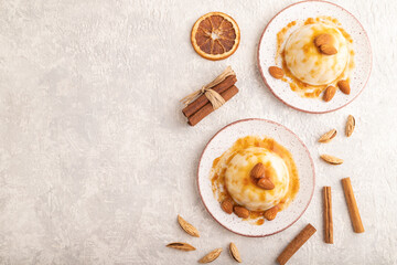 White milk jelly with caramel sauce on gray concrete, top view, copy space.