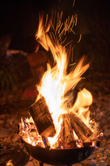 campfire burning in a fire barrel at night