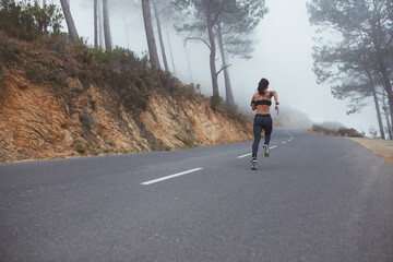 Obraz premium Female runner sprinting along a country road