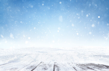 Fototapeta na wymiar defocused winter background with snowfall and snow covered empty wooden walkways