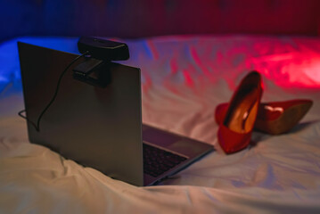 Laptop with webcam on the bed. Adult webcam work concept. - obrazy, fototapety, plakaty