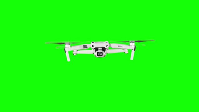 Real quadcopter with camera flights on a green screen. A drone hovering in the air with an alpha channel. Isolated portable copter on alpha matte. Aircraft blades rotate in hanging. Alpha channel 4K