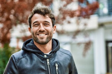 Handsome hispanic man with beard smiling happy outdoors
