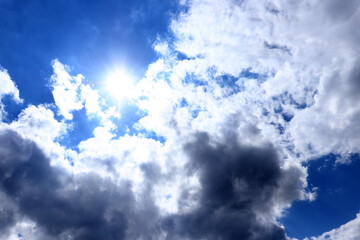 Cloudy sky background. Blue sky, sun and clouds. Copy space.