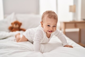 Adorable toddler smiling confident crawling on bed at bedroom