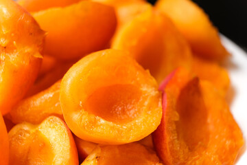 Fototapeta na wymiar Juicy apricot slices on a black background, side view.