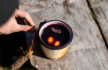 Hot mulled wine in an iron mug cooked on fire