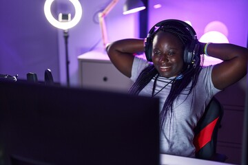 African american woman streamer smiling confident relaxed with hands on head at gaming room