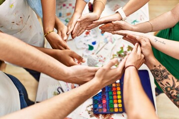 Group of people with hands together art studio.