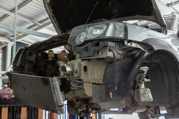  A car mechanic is checking items that need replacement parts for a customer who repairs a car at a garage.
