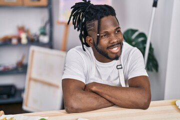 African american woman smiling confident sitting with arms crossed gesture at art studio