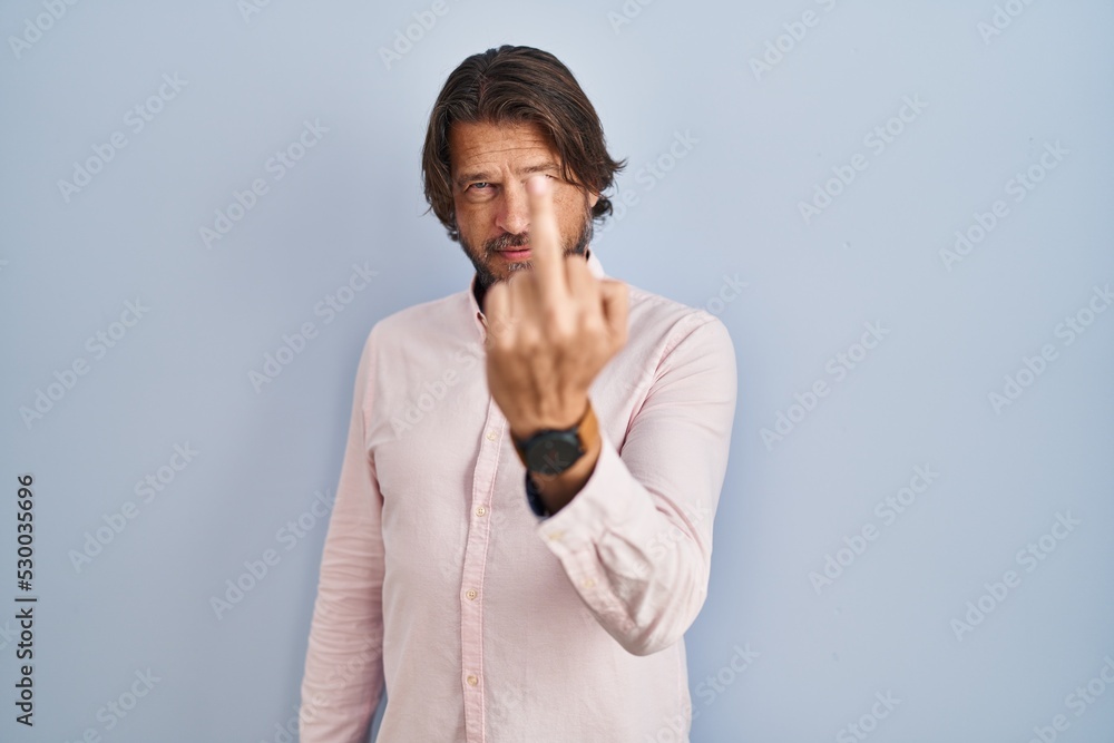 Sticker Handsome middle age man wearing elegant shirt background showing middle finger, impolite and rude fuck off expression