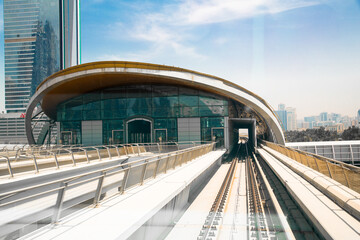 Dubai, UAE.  Dubai tube,  metro railway track, train station and City buildings