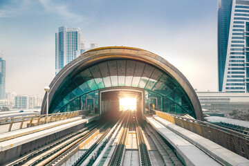 Dubai, UAE.  Dubai tube,  metro railway track, train station and City buildings