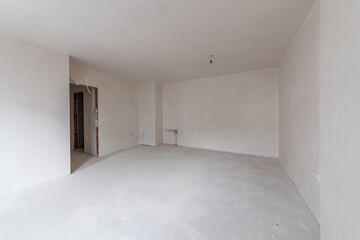 New empty room under construction. Plaster walls. New home. Concrete walls. Interior renovation.
