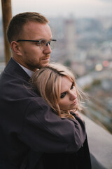 Romantic, young and happy caucasian couple in stylish clothes on the rooftop enjoying view and time together. Art portrait of beautiful woman and man. Love, relationships, romance, happiness concept.