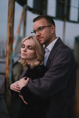 Romantic, young and happy caucasian couple in stylish clothes on the rooftop enjoying view and time together. Art portrait of beautiful woman and man. Love, relationships, romance, happiness concept.